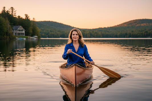 Elegant woman paddling a canoe on a serene lake at golden hour, radiating health and vitality - Restivo Health and Wellness